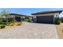 Inviting two-car garage with a brick-paved driveway and manicured landscaping at 9475 W Rosada Way, Las Vegas, NV 89149