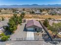 An aerial view showcases this single-story house's roof and desert surroundings at 100 Eton St, Pahrump, NV 89048