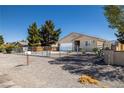 A single-story house featuring desert landscaping and a gate surrounding the property at 100 Eton St, Pahrump, NV 89048