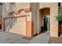 Close-up of a two-car garage and entryway with desert landscaping and a well-maintained walkway at 10988 Salernes St, Las Vegas, NV 89141