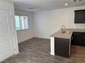 A modern kitchen featuring granite countertops, stainless steel sink, and wood-look flooring at 12112 Polar White Ct # 3, Las Vegas, NV 89183
