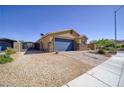 Single-story home featuring desert landscaping, gravel yard, and a two-car garage with a stone facade at 2099 Port Royal Dr, Laughlin, NV 89029