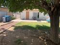 The backyard features a grassy area, concrete patio, and shade from a large tree, perfect for outdoor enjoyment at 225 Dogwood St, Henderson, NV 89015