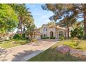 Stately two-story home featuring mature landscaping, large driveway, and lush green lawn at 2346 Villandry Ct, Henderson, NV 89074