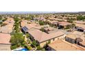 Wide aerial view of the neighborhood showcasing the tile roofs and mature landscaping of the surrounding houses at 2373 Ozark Plateau Dr, Henderson, NV 89044