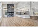 Bright, open-concept living area features a floor-to-ceiling fireplace and hardwood floors at 2409 Alpine Meadows Ave, Henderson, NV 89074