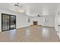 Spacious living room with fireplace, ceiling fan, and sliding glass door at 3935 Tirana Way, Las Vegas, NV 89103