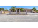Beautiful desert home featuring an ornate metal security gate, block wall and mature landscaping at 4011 Scott Russell Ct, North Las Vegas, NV 89031