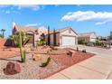 A one-story home with a two-car garage is accentuated by xeric landscaping at 420 Aloha Dr, Henderson, NV 89015
