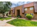Attractive condo building with lush lawn, mature tree, and cozy front garden at 5240 Indian River Dr # 273, Las Vegas, NV 89103