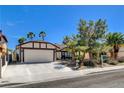 Single-story home with mature landscaping, desert plants, and a two-car garage at 6521 Faith Peak Dr, Las Vegas, NV 89108