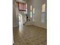 Bright living room features tile floors and a staircase with white railings at 7228 Chic Ave, Las Vegas, NV 89129