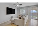 Bright living room featuring a comfortable sectional couch, ceiling fan, and sliding glass doors at 9035 Drummer Bay Ave, Las Vegas, NV 89149