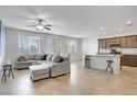 Open living space with a kitchen island, comfortable sectional couch, and ample natural light at 9035 Drummer Bay Ave, Las Vegas, NV 89149