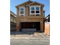 New construction home featuring a partially framed facade with modern windows and open garage space at 9082 Rivington Ave, Las Vegas, NV 89148