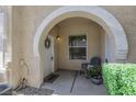 Inviting front porch with a charming archway, chair and potted flowers creating a warm welcome at 10001 Peace Way # 1250, Las Vegas, NV 89147
