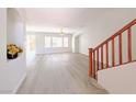 Bright living room featuring wood floors, large windows, and staircase at 10469 Mulvaney Cir, Las Vegas, NV 89141