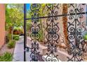 Landscaped courtyard with mature trees and decorative ironwork at 10667 Olympic Pine Dr, Las Vegas, NV 89135