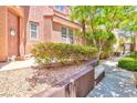 Well-maintained front yard with manicured bushes, rock landscaping, and a walkway at 10667 Olympic Pine Dr, Las Vegas, NV 89135