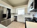 Modern kitchen with stainless steel appliances, white cabinets, and a stylish tiled backsplash at 2035 E Warm Springs Rd # 1017, Las Vegas, NV 89119