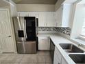 Well-lit kitchen with stainless steel refrigerator, quartz countertops, and stylish backsplash at 2035 E Warm Springs Rd # 1017, Las Vegas, NV 89119