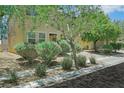 Attractive home featuring desert landscaping, including shrubs and trees in the front yard at 2117 Leatherbridge Ct, North Las Vegas, NV 89081