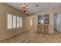 Bright dining room featuring wood-look tile flooring and access to the kitchen with breakfast bar at 2304 Willow Wren Dr, North Las Vegas, NV 89084