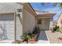 View of front door and garage, with potted plants decorating the walkway at 2304 Willow Wren Dr, North Las Vegas, NV 89084
