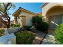 Inviting entrance with a decorative front door, stone accents, and lush landscaping at 2386 Hardin Ridge Dr, Henderson, NV 89052