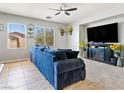 Comfortable living room with plush blue sofa, ceiling fan, and natural light at 3040 Balcones Fault Ave, North Las Vegas, NV 89081