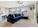 Living room with a plush blue sectional couch, ceiling fan, and neutral decor at 3040 Balcones Fault Ave, North Las Vegas, NV 89081