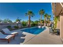 Serene backyard oasis featuring a pool, spa, palm trees, ample seating, and well-maintained landscaping at 3088 Paseo Mountain Ave, Henderson, NV 89052