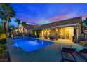Beautiful backyard showcasing a refreshing pool, mature palm trees, a covered patio with seating, and lounge chairs at 3088 Paseo Mountain Ave, Henderson, NV 89052