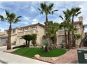 Desert home with manicured landscaping, mature palm trees, and a second-story balcony at 3340 Shallow Pond Dr, Las Vegas, NV 89117