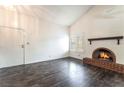 Cozy living room with dark wood floors, brick fireplace, vaulted ceiling and bright light at 4016 Stormcrest Dr, Las Vegas, NV 89107