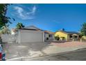 Attached garage with wide driveway and low-maintenance desert landscaping at 4496 Skyview Dr, Las Vegas, NV 89104