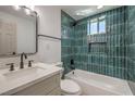 Modern bathroom showcasing a tub, vanity, and elegant teal tiling at 5200 Blanton Dr, Las Vegas, NV 89122