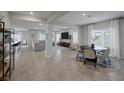 Open-concept living and dining area with tile floors, modern furniture, and ample natural light at 5234 Savannah Rose St, Las Vegas, NV 89149