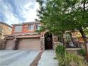 Charming two-story home featuring a three-car garage, stone accents, and a cozy front porch at 530 Calahonda Ct, Las Vegas, NV 89138