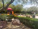 Community playground with colorful play structure, surrounded by trees and landscaping for a fun outdoor experience at 530 Calahonda Ct, Las Vegas, NV 89138