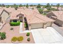 Aerial view showcases the home's tile roof, landscaping, and three-car garage at 5704 Owl Butte Ct, Las Vegas, NV 89149