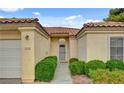 Attractive home exterior with manicured bushes, a welcoming front door, and an attached garage at 7232 Vista Bonita Dr, Las Vegas, NV 89149