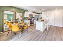 Open kitchen and dining area with stainless steel appliances, white cabinetry, and contemporary decor at 7351 Kyle Cove Dr # Lot 208, North Las Vegas, NV 89084