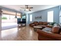 Comfortable living room with wood floors, leather furniture and sliding glass doors leading to a patio at 754 Tallgrass St, Las Vegas, NV 89138