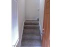 Entryway featuring a staircase with carpeted steps, white trim, and a view of the upper level at 7701 W Robindale Rd # 259, Las Vegas, NV 89113