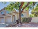 Exterior view of a charming two-story home with an attached two-car garage and mature landscaping at 7968 Lisa Dawn Ave, Las Vegas, NV 89147
