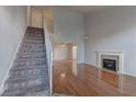 Spacious living room with a cozy fireplace, staircase, and hardwood floors at 7968 Lisa Dawn Ave, Las Vegas, NV 89147