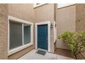 Inviting front entrance features a blue door, tan siding, and a window, offering curb appeal and natural light at 10311 Birch Bluff Lane Ln, Las Vegas, NV 89145
