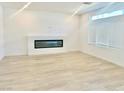 Modern living area with an electric fireplace and neutral finishes and wood-look floors at 10376 Joaquin Fire St, Las Vegas, NV 89141
