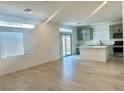 Bright, open-concept living space with hardwood floors and a modern kitchen in background at 10376 Joaquin Fire St, Las Vegas, NV 89141